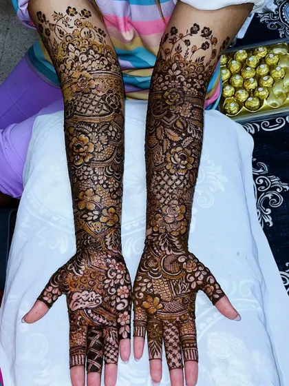 A full view of the bridal henna, with a box of chocolates in the background, a sweet treat for a long session!