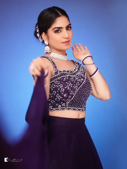 A duplicate image of the model in the purple lehenga.