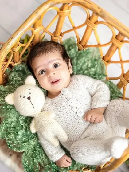 An adorable awake moment in the rattan chair. His wide-eyed look and little hand reaching out make this such an engaging and sweet portrait.