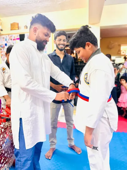 Tying the red and blue belt, a symbol of advanced learning.