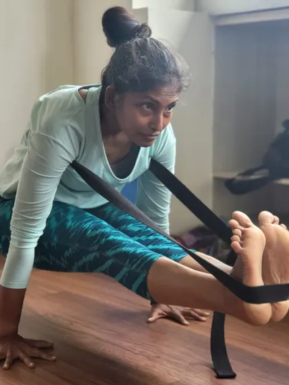 Our TTC students practice Brahmacharyasana, an arm balance, using straps to support the legs. This modification helps build the required arm and core strength while maintaining the integrity of the pose.