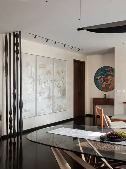 Art is a central theme in the 'Rambagh' residence. Here, the dining area is set against a backdrop of curated art pieces, including a custom black-and-white column and a triptych, demonstrating how we design spaces that serve as a personal gallery for our clients.