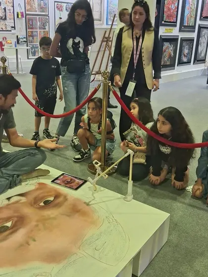 Another angle of Pramod Sahu's live art session, showing the rapt attention of the children watching him work.