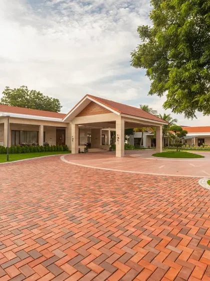 The paved brick driveway provides a textured, rustic contrast to the manicured lawns and the home's clean architectural lines. This approach ensures every element of the landscape design is considered.