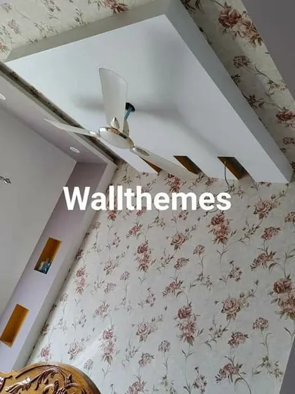 A floral wallpaper installed on both the wall and the ceiling, a unique approach that makes the room feel cozy and enveloped in pattern.