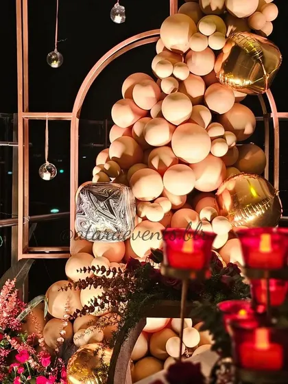 A festive balloon arrangement for a 40th birthday. The cascade of peach and gold balloons, accented with hanging glass baubles, adds a touch of glamour and celebration to the decor.