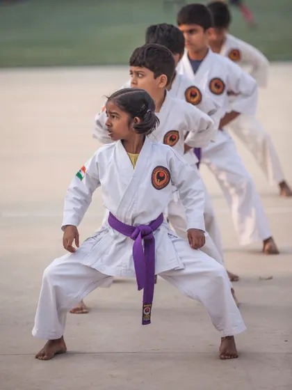 A young student holds a strong kiba-dachi (horse stance). This fundamental stance is crucial for developing power and stability.