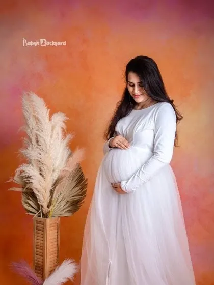 A vision in white. This beautiful solo portrait in our studio captures the pure joy and anticipation of a mother waiting to meet her baby.