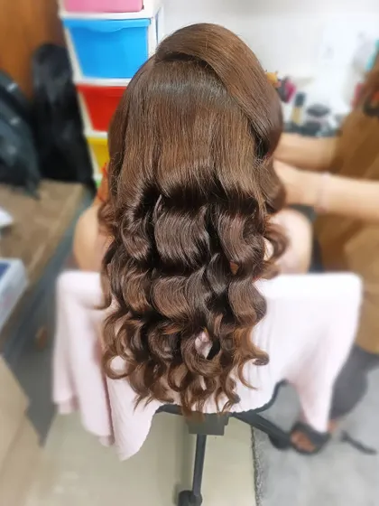 A back view of a voluminous open hairstyle with defined, bouncy curls. This is a perfect party-ready look.