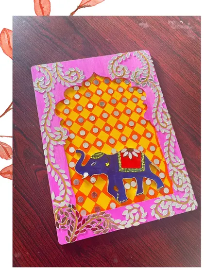 A vibrant pink Lippan art piece featuring a royal elephant design. This is a great example of combining painting with traditional craft.