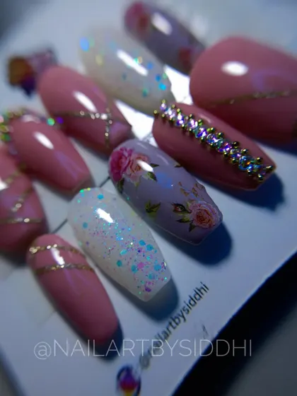 A close-up of a packaged bridal set, featuring a mix of pink, glitter, hand-painted florals, and rhinestone accents.