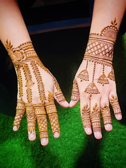 A minimalist yet striking back-of-hand mehandi design. Featuring delicate hanging jhumka (bell) motifs and a simple wristband, this style is perfect for guests or for those who love understated elegance.