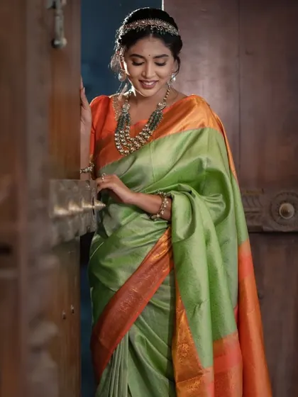 A full-length shot of the model, her elegant pose and the beautiful drape of the saree creating a picture of grace.