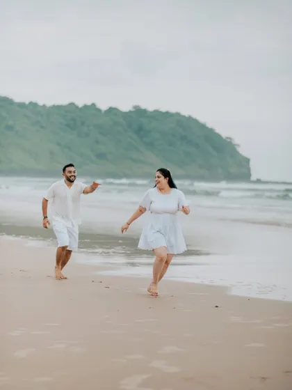 A fun, action shot of a couple running and laughing on the beach.
