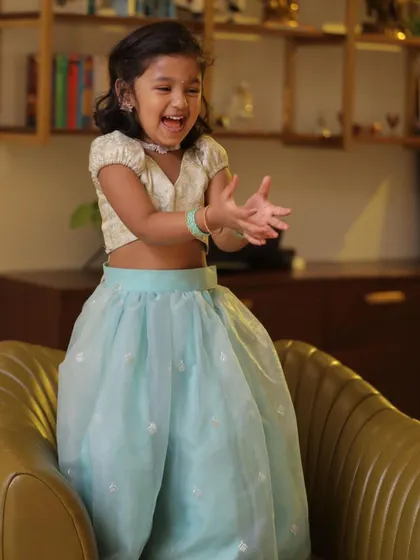 A playful moment with baby Diya in her beautiful pastel lehenga and brocade top.