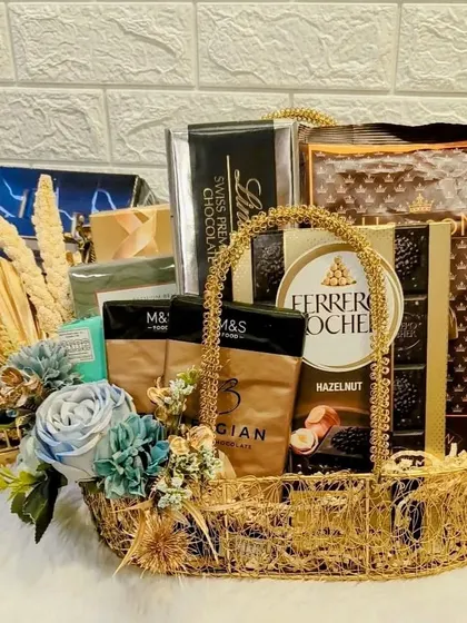 A gourmet chocolate hamper designed with a sophisticated blue and gold theme. It's filled with premium selections like Ferrero Rocher and Belgian chocolates, making it a decadent festive treat.