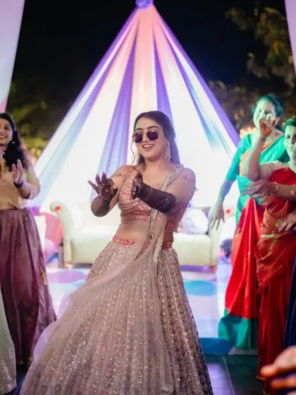 Nothing beats the energy of a mehndi party. A happy client takes center stage on the dance floor, her henna adding to the festive vibe.