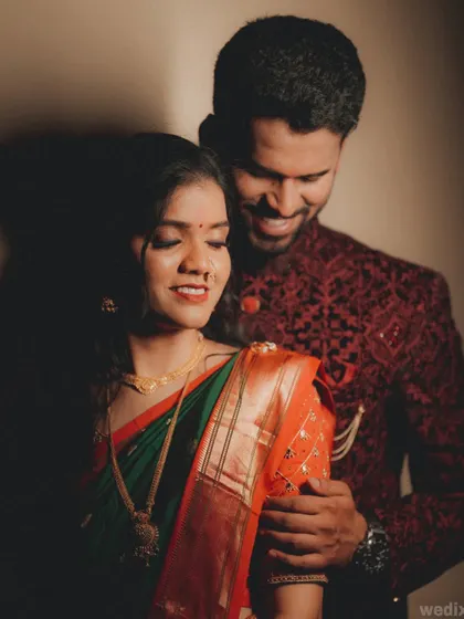 A classic wedding portrait where the groom embraces his bride from behind, creating a sense of closeness and protection.