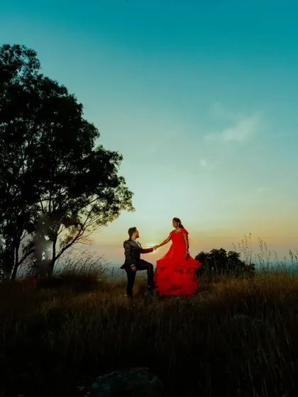 A duplicate of ID 5, this wide shot captures a couple on a hill at sunset, with the bride's red gown standing out against the beautiful landscape.