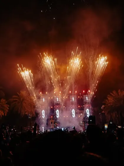 The grand finale of a New Year's Eve show, with fireworks lighting up the sky behind the stage. I always aim to end the night with a bang.