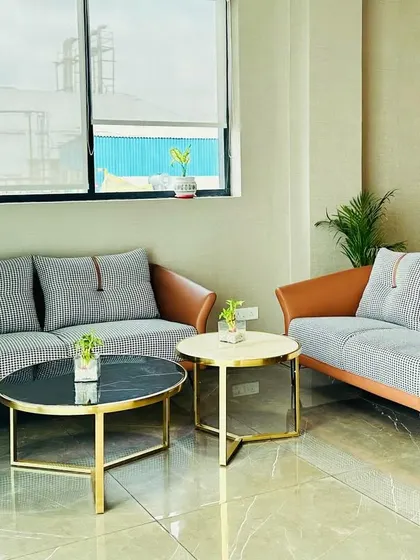 A closer look at the seating arrangement in the Ambala office reception. The combination of tan leatherette and grey fabric on the sofas provides a modern yet warm feel.