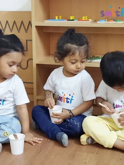 Three toddlers enjoy the delicious fruit salad they helped prepare. Sharing a meal they made themselves gives them a great sense of accomplishment.