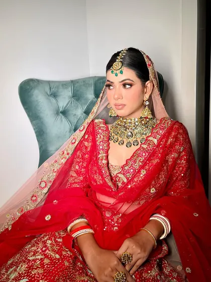 This look is all about poise and elegance. The soft smokey eye and neutral lip allow the magnificent red outfit and statement jewellery to take center stage, creating a balanced and sophisticated bridal style.