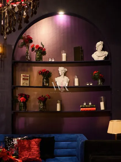 We believe every detail matters. This built-in shelf was styled with classical busts, books, and simple red floral arrangements to enhance the sophisticated, European library feel of the cocktail lounge.