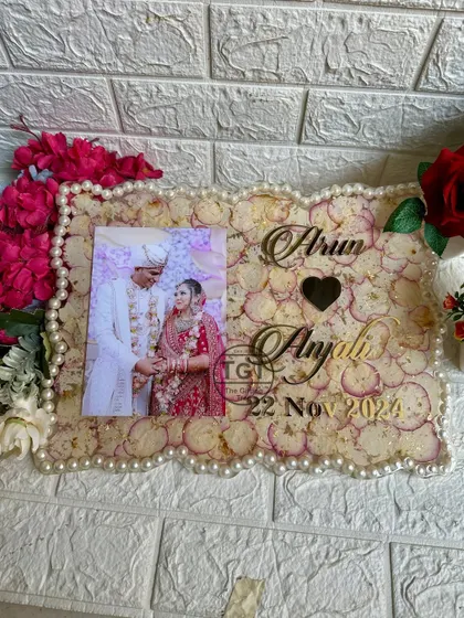 A straight-on view of the varmala preservation frame. The design includes a photo, the couple's names in a beautiful script, a heart motif, and their wedding date.