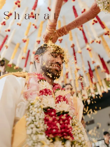 A close-up of the groom during the Talambralu ritual, where rice and pearls are showered over his head as a blessing.