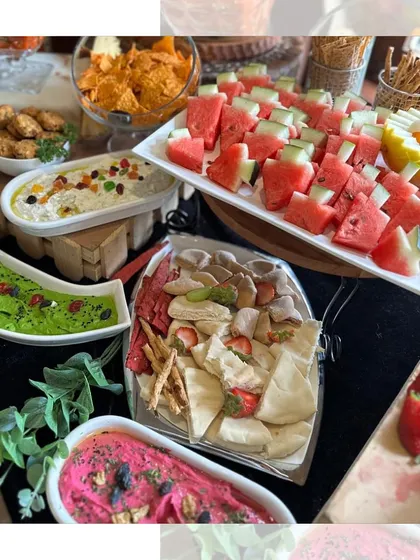 A vibrant display of our colourful dips, including beetroot hummus and edamame hummus, served with fresh pita bread, watermelon, and other dippables.