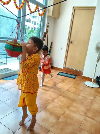 A little Krishna playfully reaches for the Dahi Handi. We encourage imaginative play that allows children to embody the stories they learn.