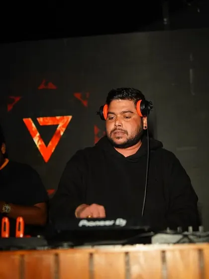 Another angle of me at the decks, with my headphones on, listening for the perfect moment to mix in the next song.