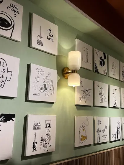 An angled view of the gallery wall, showing how the collection works with the cafe's lighting and interior design.