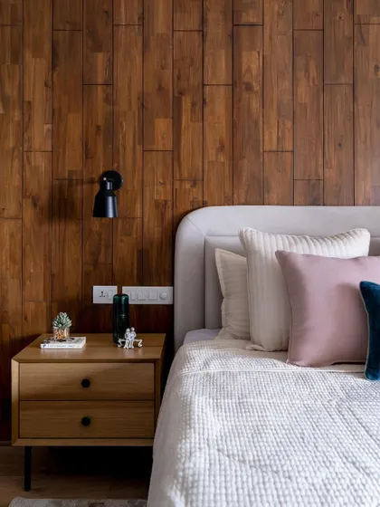 We love using wood to add warmth. This bedroom features a full accent wall of vertical wood planks, creating a cozy and sophisticated backdrop for the bed.