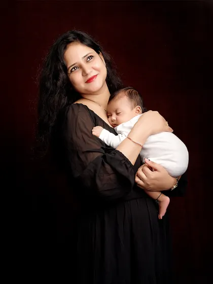 A mother's hopeful gaze as she holds her sleeping baby. This portrait is a beautiful representation of the dreams and love a mother has for her child.