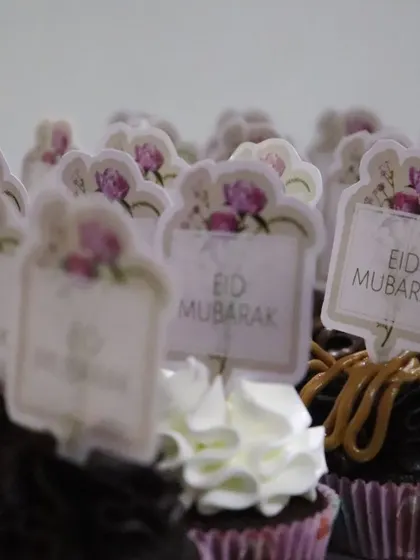 A mix of chocolate and vanilla frosted cupcakes ready for Eid, each with a custom topper.