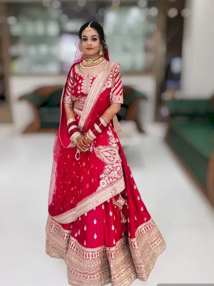 This bride's look is all about classic elegance. The makeup is clean and radiant, paired with a traditional red lehenga for her wedding day.