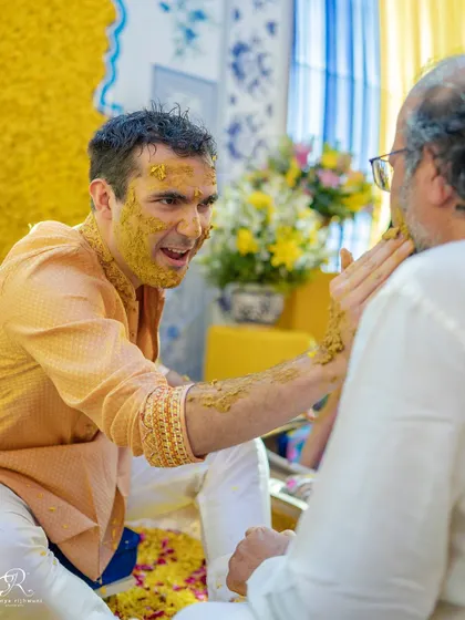 The groom sharing a fun moment with a family member during his Haldi ceremony.