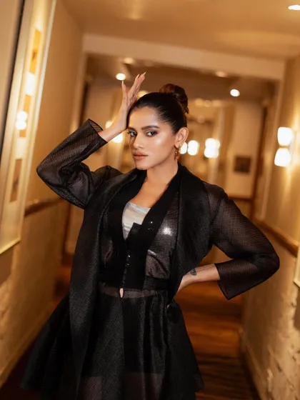 An expressive and artistic pose. The hand gesture adds a touch of drama and personality, making the image more than just a fashion shot.