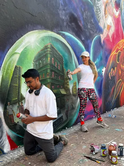 Posing with spray cans, my tools of the trade, during the IIT Bombay project. This mural was a perfect blend of spray painting for the cosmic backgrounds and brushwork for the fine details.