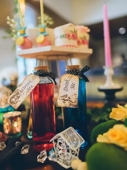 No Wonderland party is complete without a little curiosity. These corked glass bottles filled with colorful drinks and labeled "Drink Me" are a playful and iconic detail that guests love.