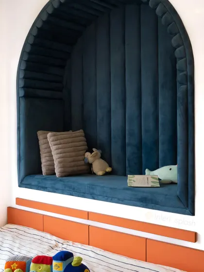 We created this cozy arched reading nook with plush blue velvet upholstery. It's a perfect little hideaway for a child to read and imagine.