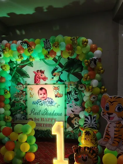 For kids' parties, themes are everything. Here is a jungle theme I did for a first birthday, complete with a personalized backdrop, animal cutouts, a full balloon arch, and a light-up number '1'.