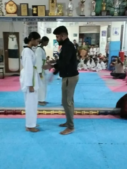 A student receives her new belt with a handshake.