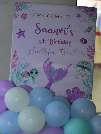 A personalized welcome sign for Saanvi's 5th birthday "shellebration". The sign is decorated with cute sea creatures and a mermaid tail, perfectly matching the under-the-sea party theme.