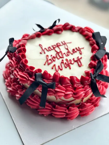 I love a good vintage buttercream and bow moment. This design features rich red buttercream piping with delicate black bows, perfect for a romantic and stylish "happy birthday wifey" cake.
