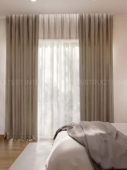 A view of the bedroom from the side, showing the elegant floor-to-ceiling curtains and the clean lines of the furniture. The design is modern, stylish, and built for comfort.