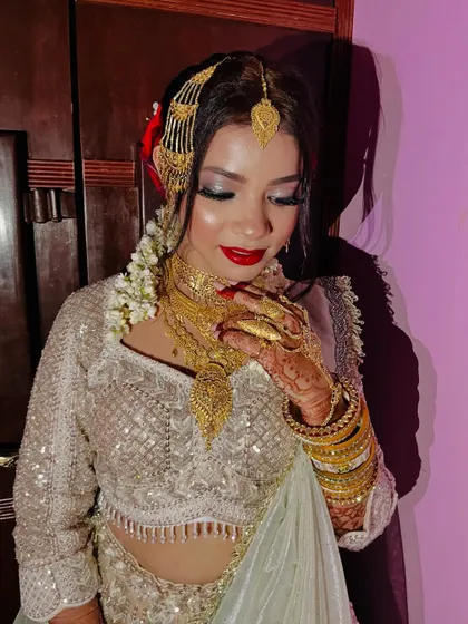 For this Nikaah bride, we went for a 'sheen glow' look. The makeup is luminous and ethereal, with silver-toned eyeshadow and a classic red lip.