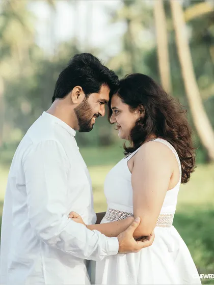 An intimate pre-wedding portrait of a couple in a close embrace, their matching white outfits symbolizing unity and peace.